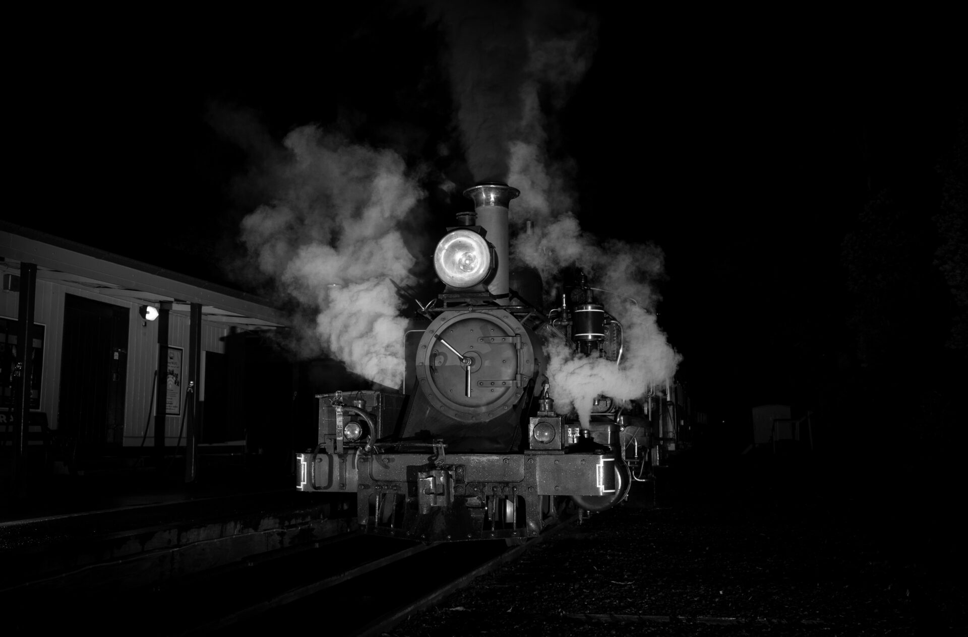 Locomotive in darkness at a station platform.