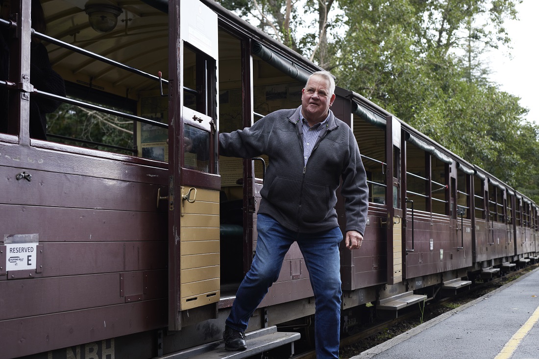 Older Male Exiting The Stationary Carriage Older male disembarking one of Puffing Billy Railway's open side carriages.