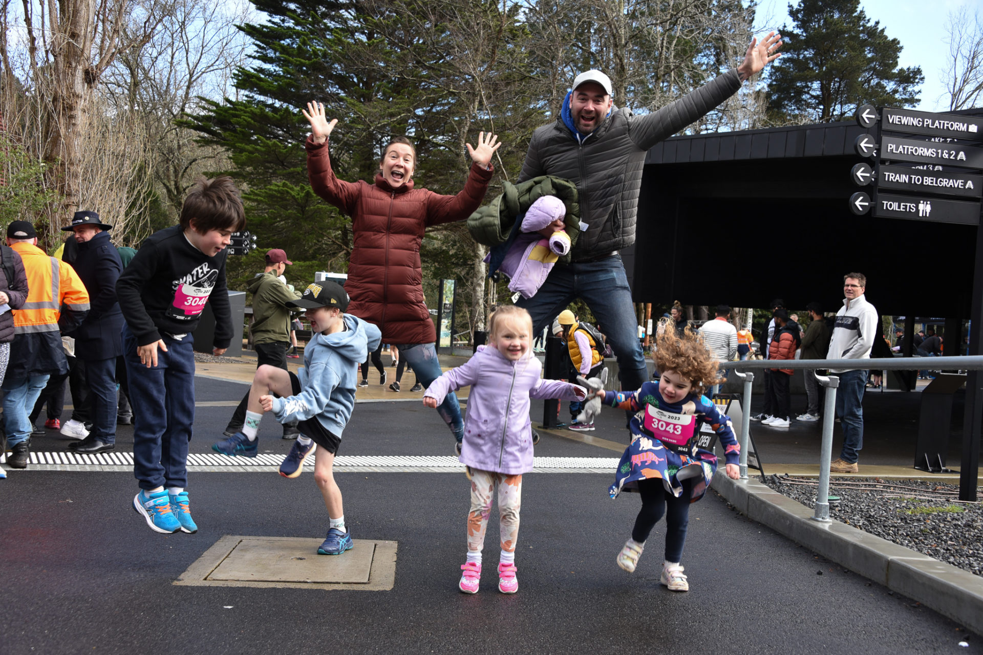 A family of four are jumping for joy outside the Lakeside Visitor Centre