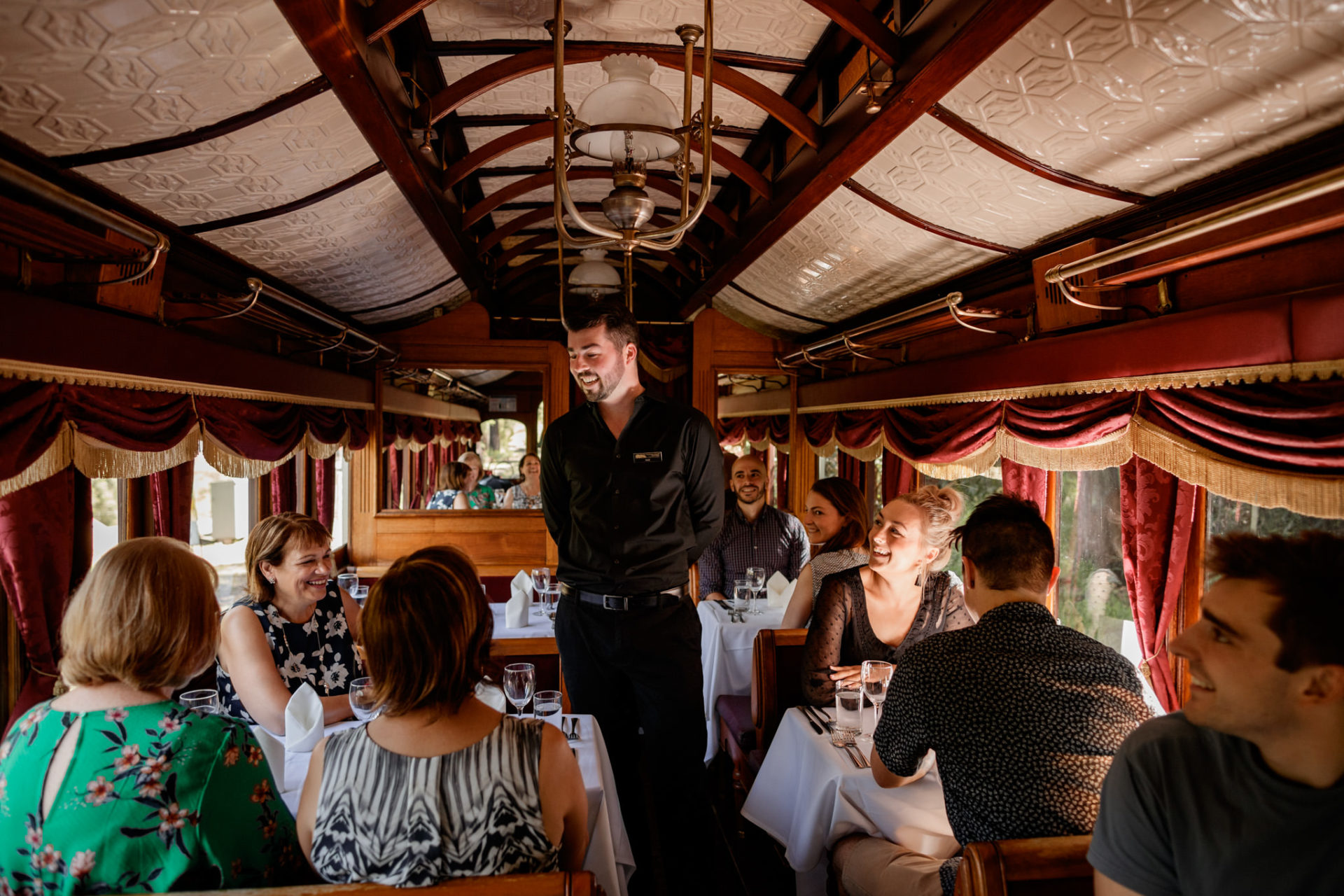 Server Talking To Guests On Board Dining Carriage