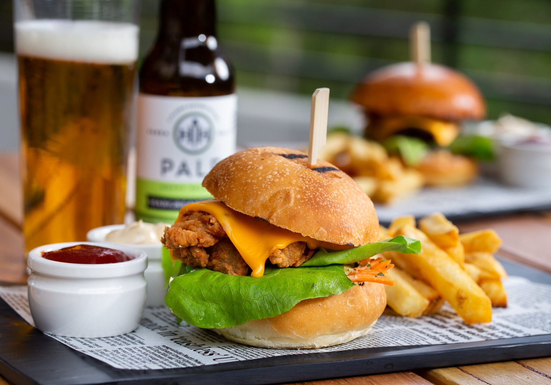 CLASSIC BEEF BURGER - 180g of char grilled beef with cos lettuce, dill pickles, white onion and American cheese, topped with burger sauce and ketchup, served with fries.