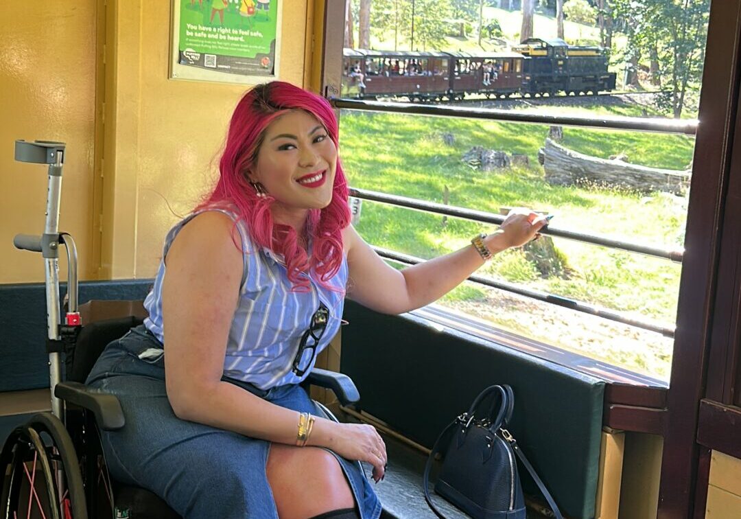 Wheelchair user onboard excursion train carriage. The person's wheelchair is positioned alongside the carriage open side window to provide a great vantage point for the journey.