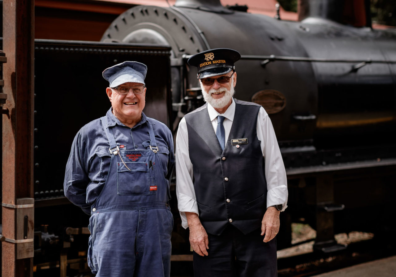 Volunteers Standing Infront Of Locomotive Station Master And Driver